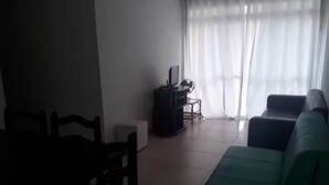 Ein Wohnzimmer mit einer Couch, einem kleinen Tisch und einer TV-Konsole.