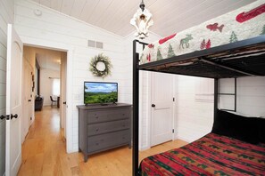 Retreat to the serene primary bedroom featuring a plush queen bed and elegant white wood-paneled walls. - 2BR Retreat - Hot Tub, Near Dollywood & Pkwy! (Pigeon Forge)