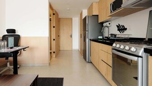 Een moderne keuken met houten kastjes, roestvrijstalen apparatuur en een zwart aanrecht.