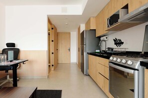 Eine moderne Küche mit Holzausstattung, Edelstahlgeräten und einer schwarzen Arbeitsplatte.