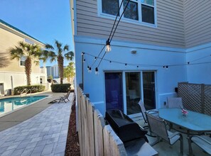 A backyard with a swimming pool, patio furniture, and a table with chairs. - Spacious 5BR • 3 Kings • Walk 2 Beach • Pool • BBQ (Panama City Beach)