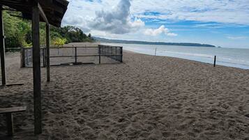 Une plage avec une structure en bois, un banc et une vue sur l’océan.