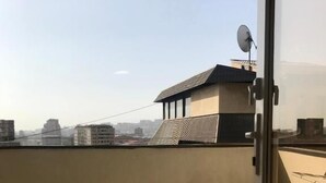 A balcony with a view of a cityscape, a satellite dish, and a door. - Guest House Aygestan Hotel (Yerevan)