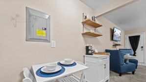 A compact living space with a dining area, kitchenette, and seating area. - Oak Shores Studio 4 | Just a Short Walk to the Beach! (Biloxi)