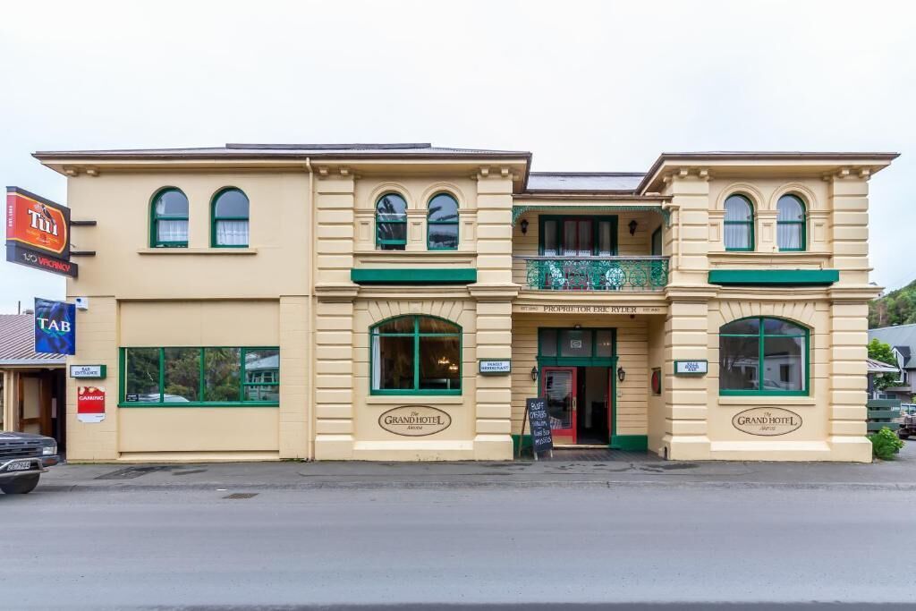 A two-story building with a sign reading "Grand Hotel".