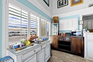 Una cocina con ventana, un refrigerador y un microondas.
