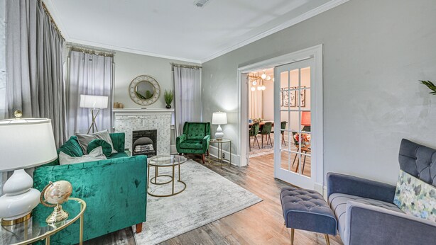A living room with a green sofa, a blue armchair, and a fireplace. - Walk to the Neuse River! New Bern Vacation Rental (New Bern)