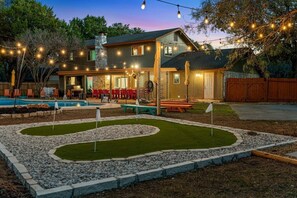 A house with a swimming pool, patio, and string lights. - Meadow Circle Estate - Pool, Spa & Outdoor Games (San Antonio)