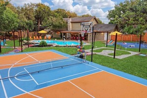 An outdoor basketball court with a pool and lounge chairs. - Meadow Circle Estate - Pool, Spa & Outdoor Games (San Antonio)