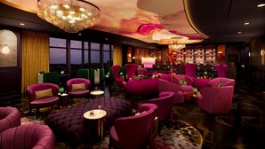 A luxurious lounge with plush seating, a bar area, and large windows.