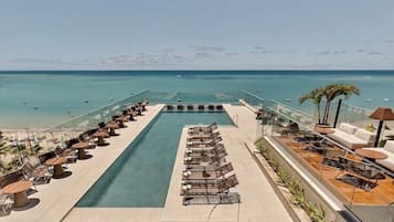 Alberca techada, alberca al aire libre y camastros