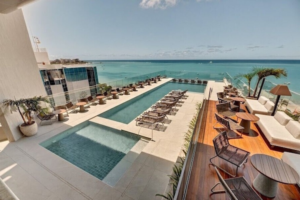 Een binnenzwembad, een buitenzwembad, ligstoelen bij het zwembad