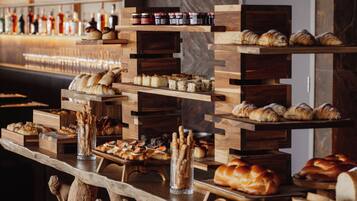 A buffet with various baked goods and pastries displayed on wooden stands.