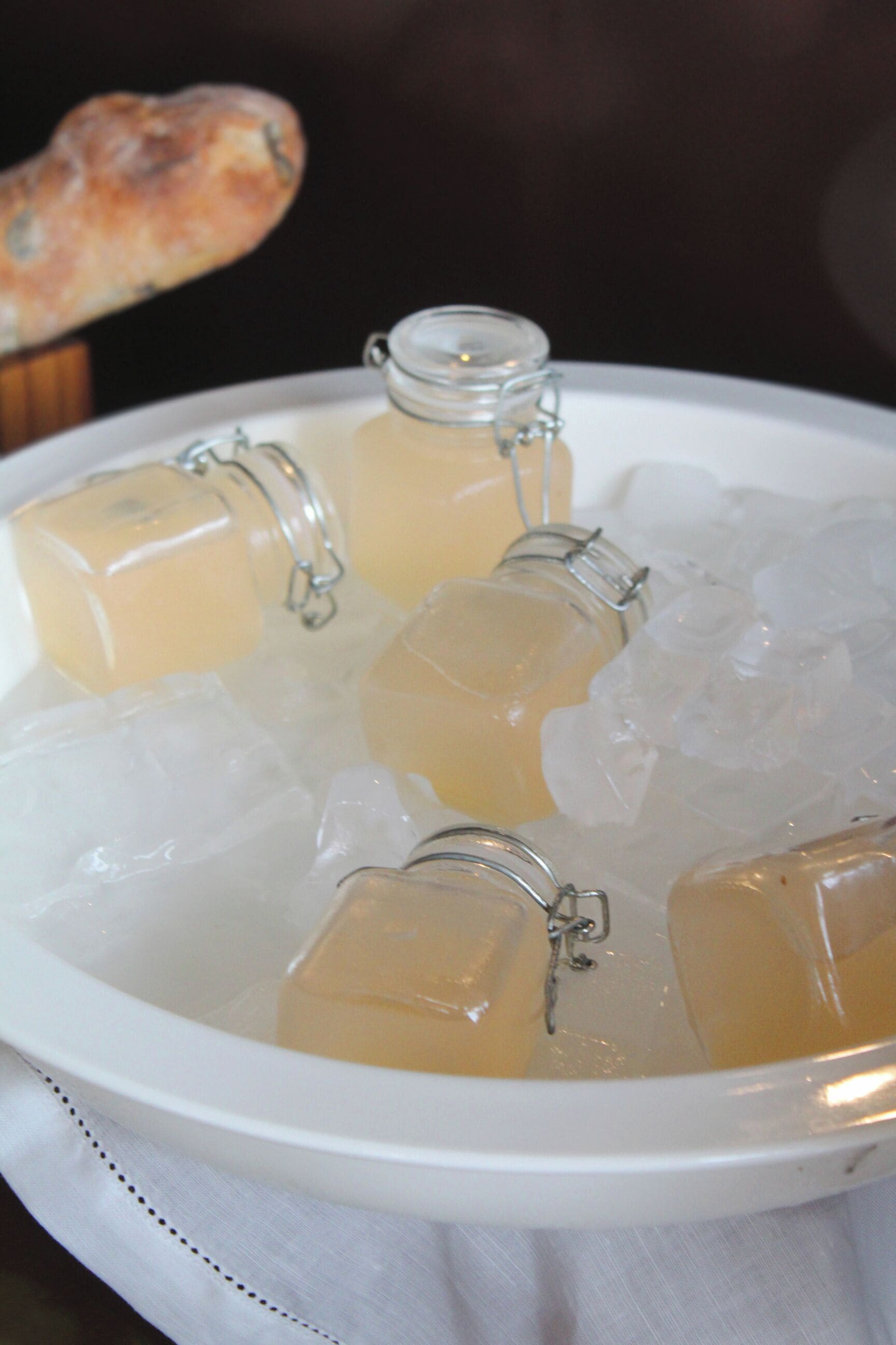 Un plateau contenant des boissons fraîches servies dans des bouteilles en verre munies de fermoirs métalliques, le tout entouré de glaçons.