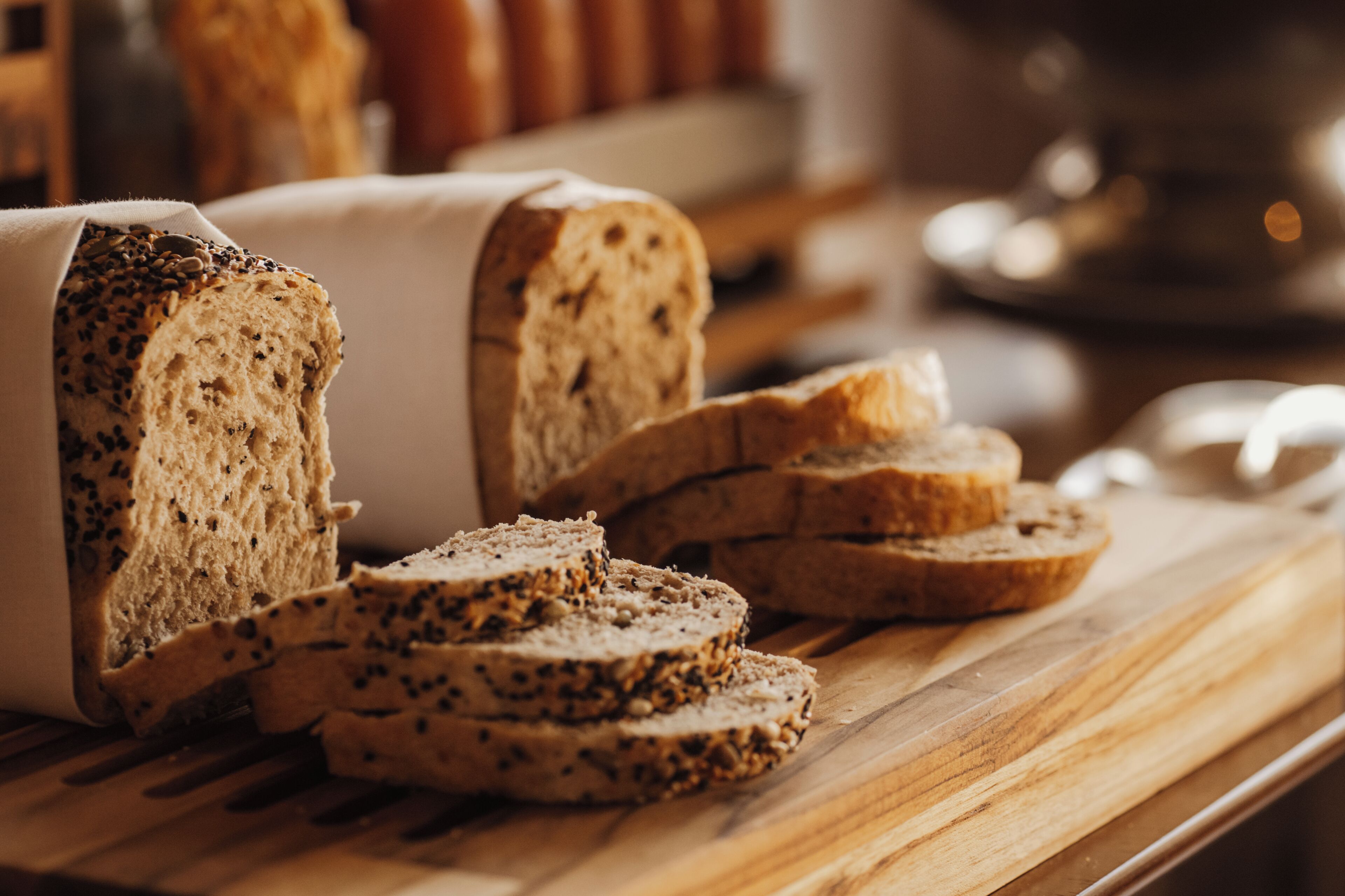 Een brood met zaden op een houten snijplank.