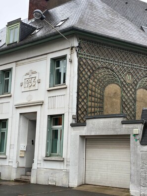 Un bâtiment dont la façade porte le numéro « 1935 », avec une porte de garage et une structure en treillis métallique sur le côté.