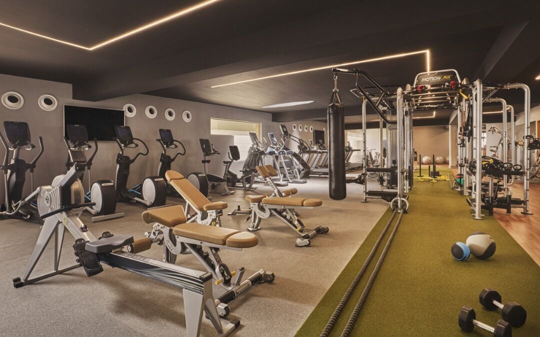 A gym with various exercise equipment, including treadmills, stationary bikes, and weight machines.