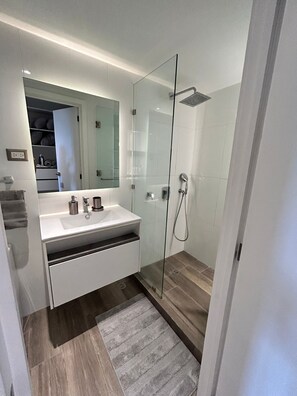 Een douche, handdoeken, zeep, toiletpapier