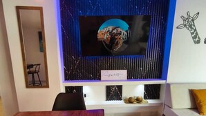 Ein stilvoller Essbereich mit einem Holztisch, schwarzen Stühlen und einem Topfpflanzen.
