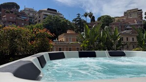 Ein Whirlpool mit Blick auf umliegende Gebäude und Bäume.