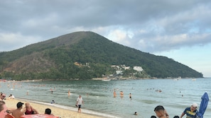 A beach with people swimming and walking along the shore. - Marin de Sá - 500 meters from the beach (Caraguatatuba)