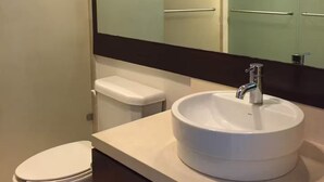 Ein Badezimmer mit Waschbecken, Spiegel und Toilette.