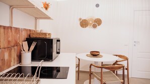 A compact kitchen with a microwave, toaster, and a small dining table with chairs. - OAZA Romance Suite with Jacuzzi | Catania (Catania)