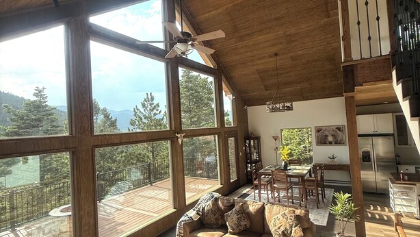 A spacious living room with a large wooden ceiling, a sofa set, a dining area, and a view of the outdoors. - Bear House in the mountains Cuchara Co. (La Veta)
