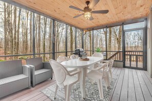 A covered outdoor area with a white table and chairs, a gray sofa, and a ceiling fan. - Calm Waters w/ Hot Tub, Game Room & Patio (Lake Ariel)