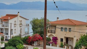 Una zona residenziale sul lungomare, con case dotate di balconi e vista sul mare e sulle montagne sullo sfondo.