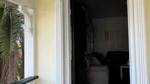 Uma porta de entrada para uma sala de estar com sofá e piso de azulejos.