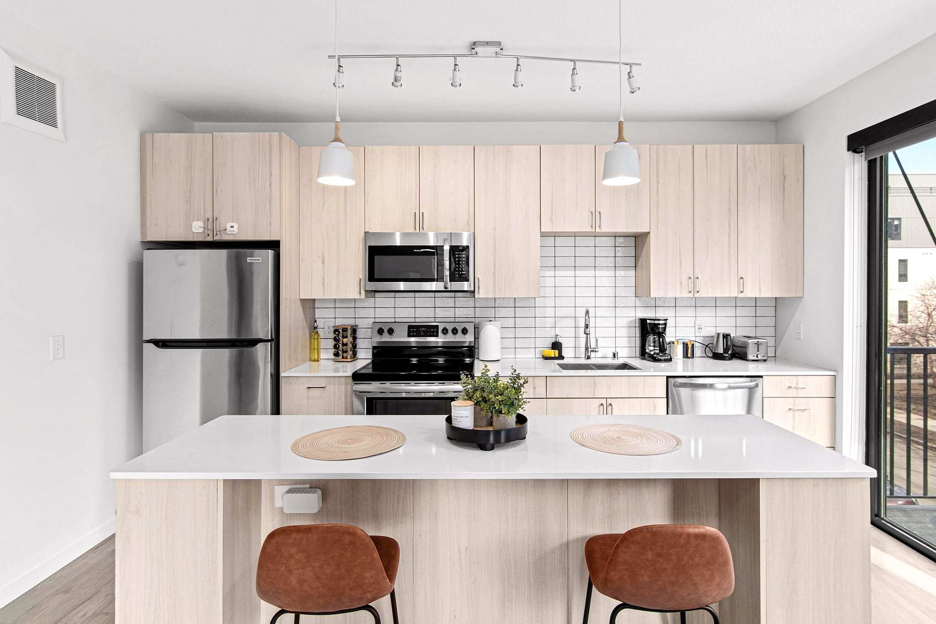 Bright, Fully Equipped Kitchen - Sleek kitchen with stainless steel appliances, bar seating, and all essentials for cooking or enjoying a morning coffee.