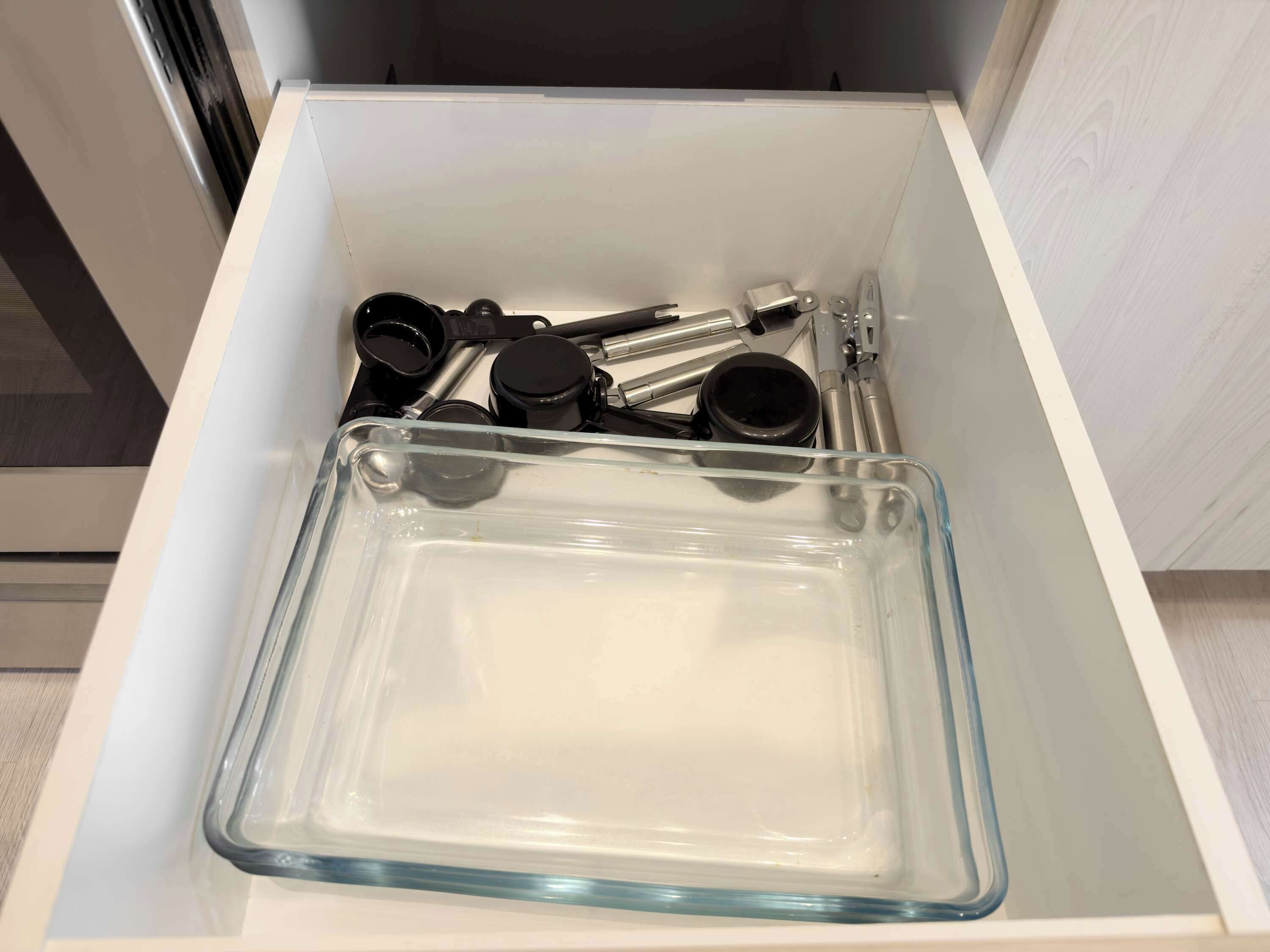 Another well-organized kitchen drawer, featuring glass containers and additional cooking essentials. This drawer ensures you have easy access to storage and utensils, maintaining an organized cooking space.
