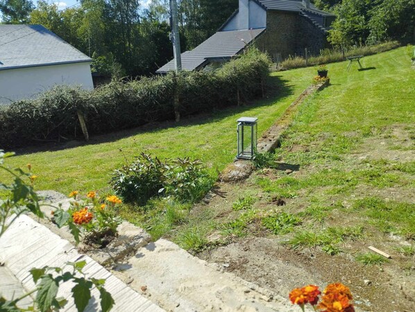 Un quartier rĂ©sidentiel avec un chemin menant Ă une maison, entourĂ©e de verdure et dâun petit jardin fleuri.