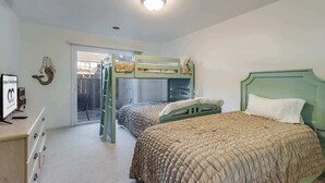 A bedroom with bunk beds, a desk with a computer, and a window with a view of the outside. - Club Ocean Villas I 42 (Ocean City)