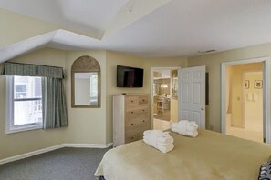A bedroom with a bed, a dresser, a television, and a window with curtains. -  Stunning Ocean Palms 3BD/3BA villa with free golf, tennis and pickleball! (Hilton Head Island)