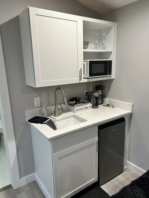 Frigorífico, microondas, cafetera o tetera y utensilios de cocina