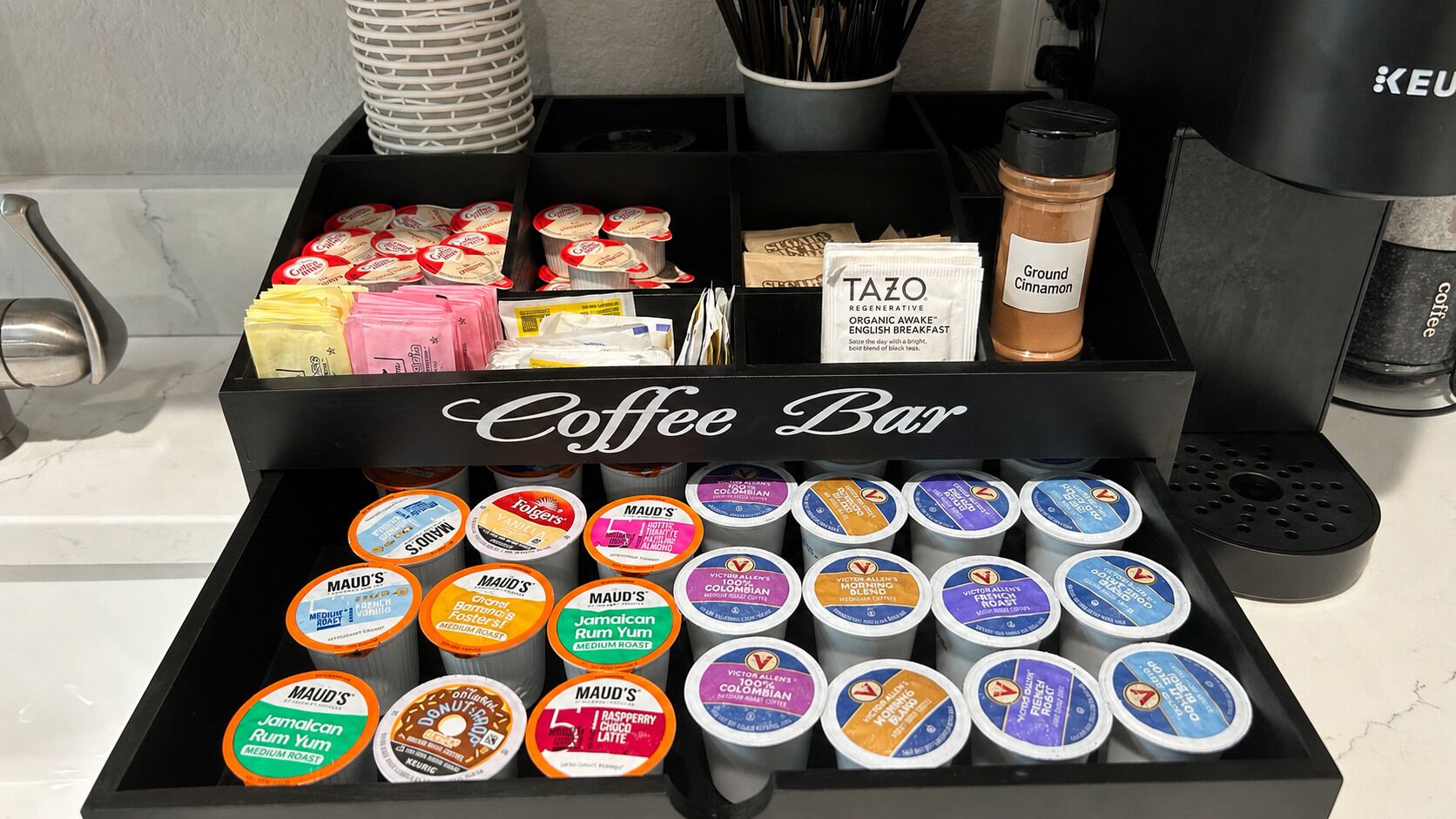 A coffee bar with a variety of coffee pods and a Keurig coffee machine.