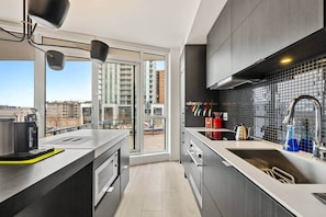 Fridge, microwave, oven, stovetop - The Current - Chic East Village Condo - Near River (Calgary)