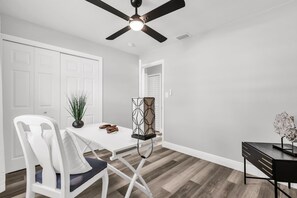 A modern kitchen with white cabinetry, a dining table, a ceiling fan, and a decorative plant. - Resort Like Winter Park Pool Home (Winter Park)