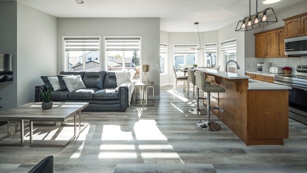 Una cocina moderna con armarios de madera, una isla central y un comedor con banco.