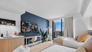 Een moderne hotelkamer met een groot bed, een bureau, een stoel en uitzicht op de stad.