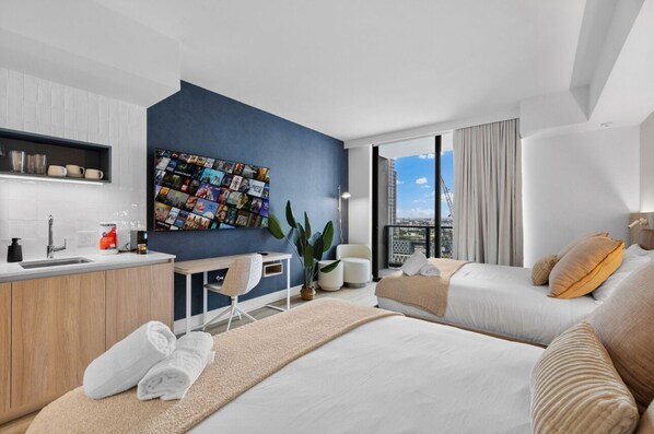 A modern hotel room with a large bed, a desk, a chair, and a view of the city. - 2105 - Modern studio with Balcony, Pool and a 24/7 Gym in Downtown Miami (Miami)
