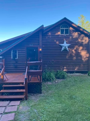 A wooden cabin with a star decoration, a porch, and a number '862' on the door.