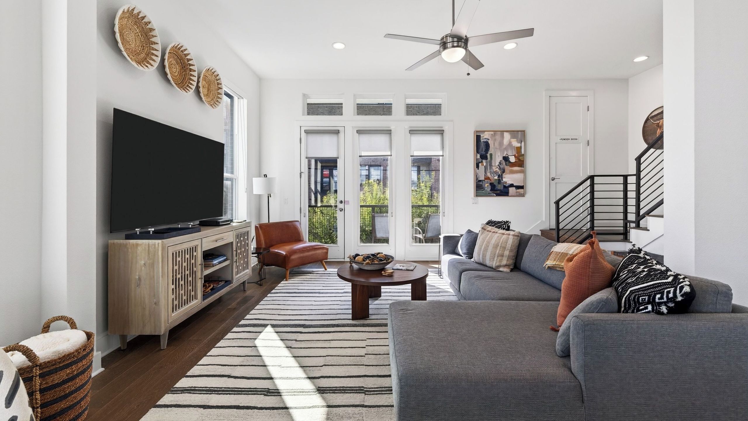 A living room with a TV, leather sofa, and a coffee table.