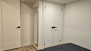 Une chambre à coucher avec un lit, une armoire et un miroir.