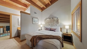 A bedroom with a bed, two bedside tables, a wall-mounted fur rug, and a window with blinds. - Unique Northstar Cabin w/ Fireplace Minutes to Skiing, Trails, and Town Alpine Bend by Avantstay (Truckee)