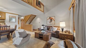 A spacious living area with a staircase, a sofa set, a coffee table, and a lamp. - Unique Northstar Cabin w/ Fireplace Minutes to Skiing, Trails, and Town Alpine Bend by Avantstay (Truckee)