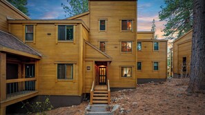 Un edificio in legno a più piani con una scala centrale, numerose finestre e un ambiente naturale circostante.