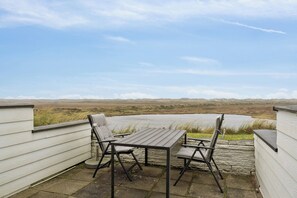 A patio with a table and chairs overlooking a landscape. - Holiday home with views and peace by the fjord (Nørre Nebel)